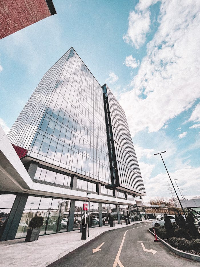 The Art of Drawing Readers In: Your attractive post title goes here Contemporary glass office tower reflecting the sky, showcasing modern architectural design.